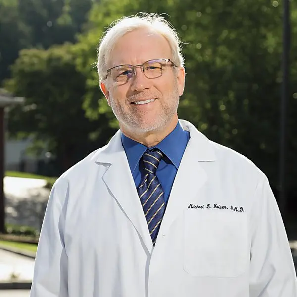 Image of Michael L. Golsen, DMD, MBA in a white coat, smiling.