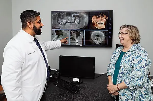 Dr. Rishi Kapur in a consultation with a patient showing them an X-ray.