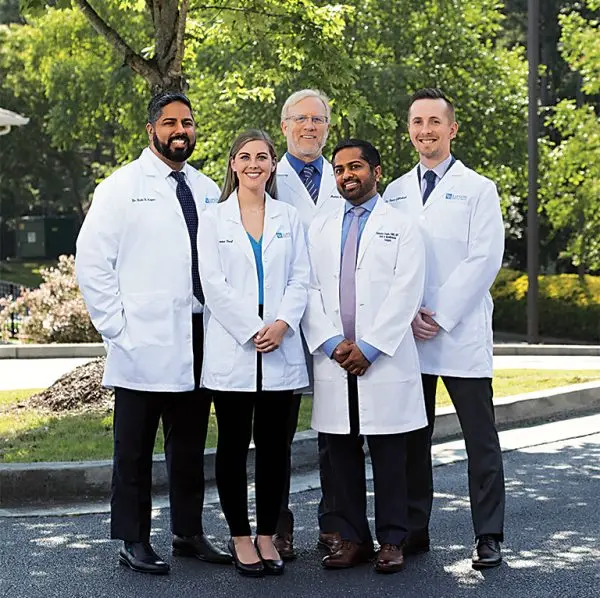 Image of the doctors standing outside in white coats.